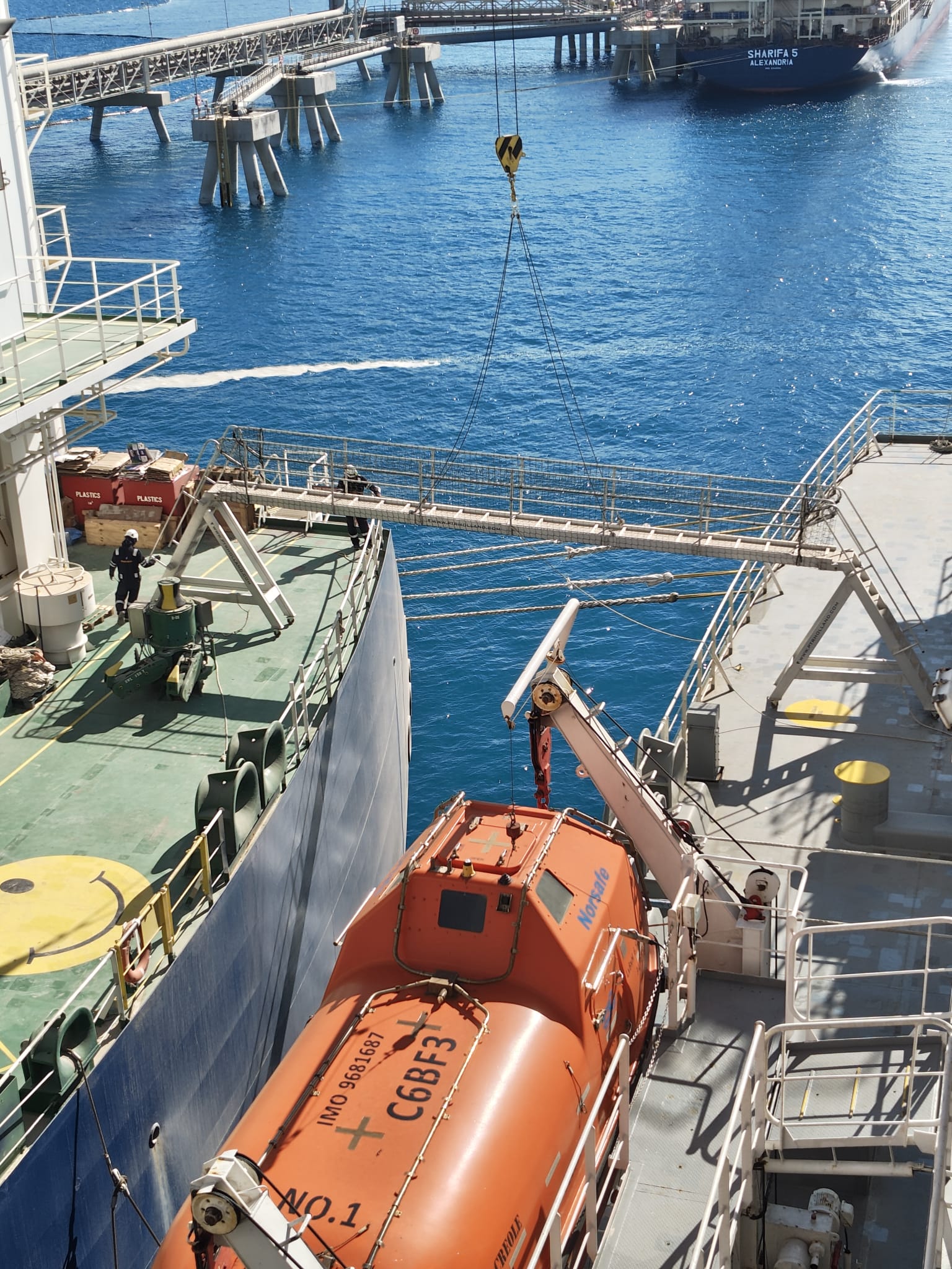 Gangway rigged between the vessels with the LNG carrier Sharifa 5 passing the Ain Sukhna terminal beyond