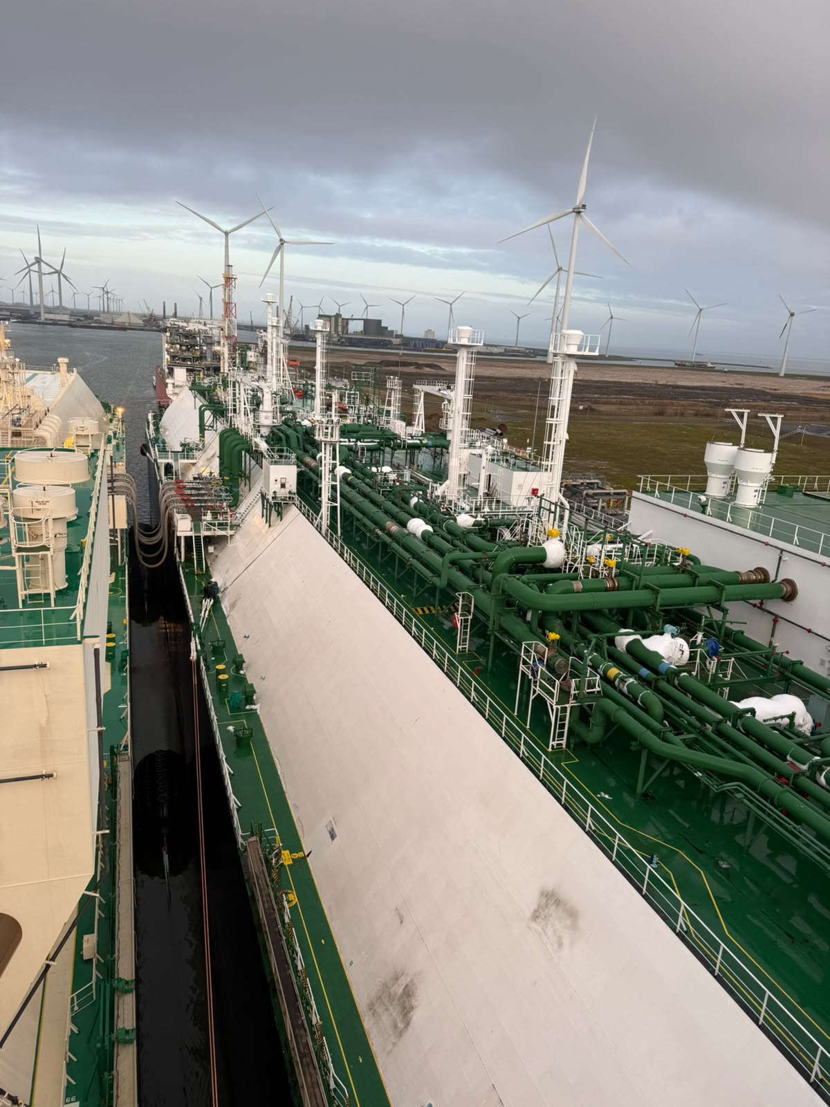 Transfer manifolds on deck with the Eemshaven wind turbines beyond