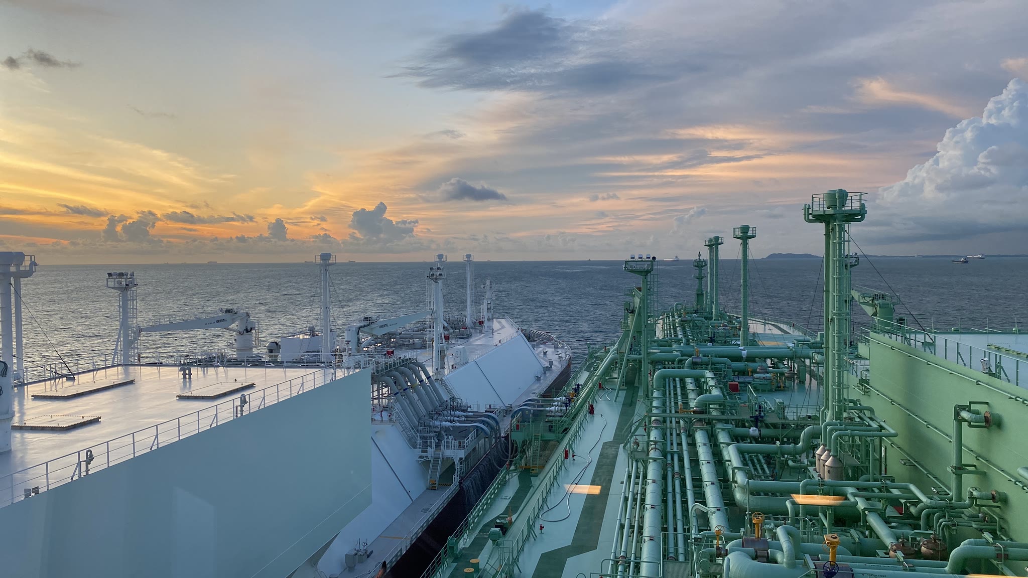 LNG carriers conducting a ship-to-ship transfer at sunset